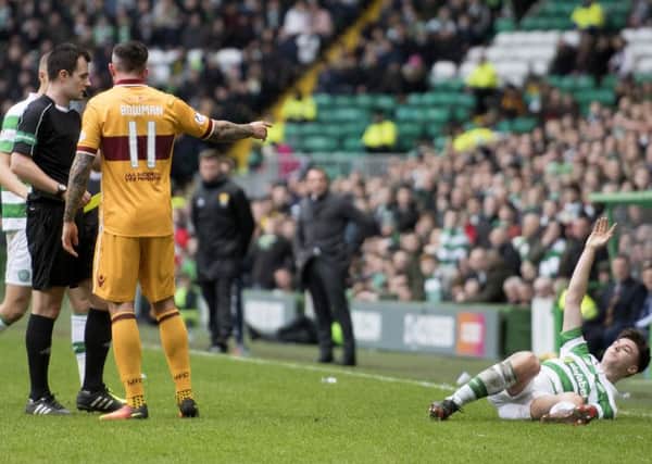 Celtic's Kieran Tierney (right) on the deck after the challenge by Ryan Bowman. Picture: SNS