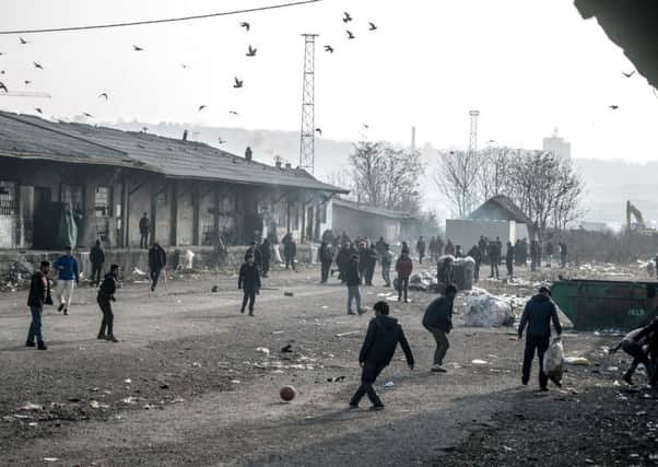 Kicking a football on the waste ground outside the Barracks. Picture: Andrew Testa/Panos for Christian Aid