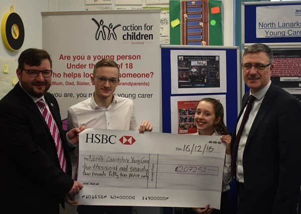 Callum Thorn holding cheque for North Lanarkshire Young Carers