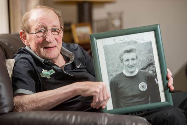 Tommy Gemmell pictured in 2014, holding a framed photo of himself in Scotland kit. Picture: Ian Georgeson