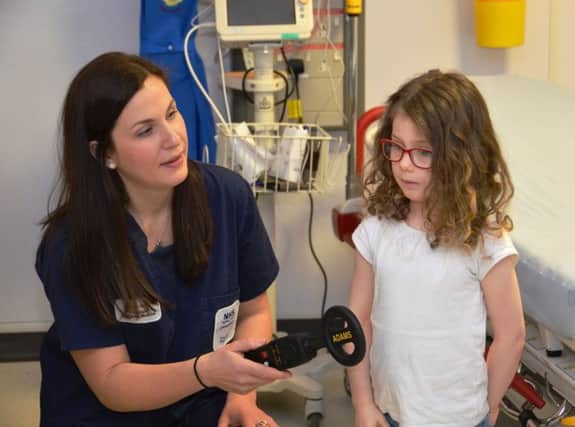 Emergency department consultant Dr Fiona Hunter examines youn g patient Anna with the metal detector. Picture: Contributed