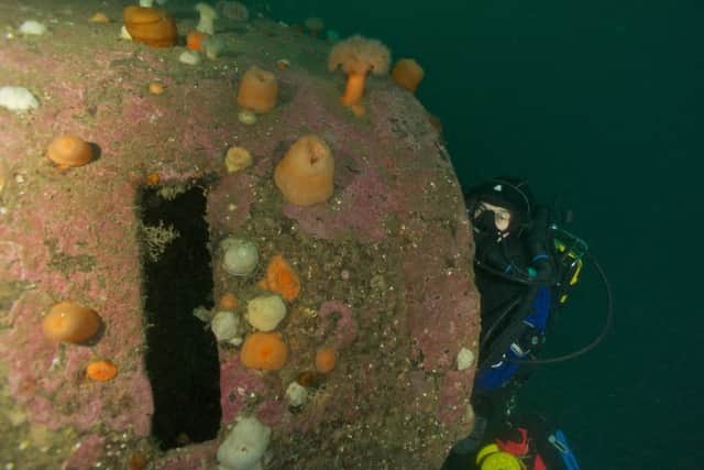 A diver explores the spotting top of a battleship. The slot to the left is a viewing slit. Picture: BSAC