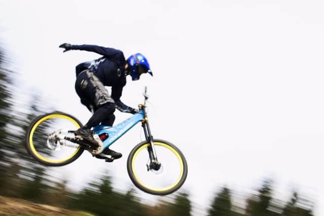One handed, rodeo style, a mountain biker flies through the air at Glentress, Scottish borders. Picture: Graham Riddell