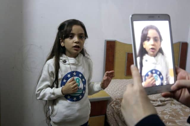 Syrian Bana al-Abed is filmed by her mother as they prepare to post on Twitter in English about life in the besieged eastern districts of Syria's Aleppo. Picture: Thaer Mohammed/AFP/Getty Images