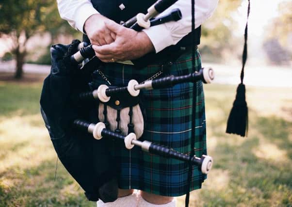 Bagpipe player dons his kilt colours.