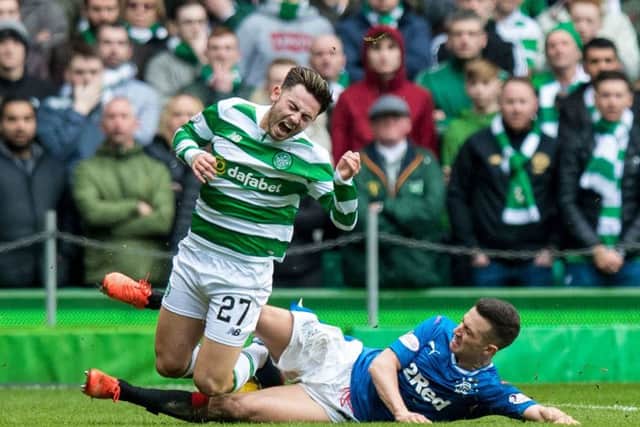 Celtic's Patrick Roberts (left) is tackled by Rangers' Jason Holt. Picture: SNS