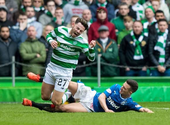 Celtic's Patrick Roberts (left) is tackled by Rangers' Jason Holt. Picture: SNS