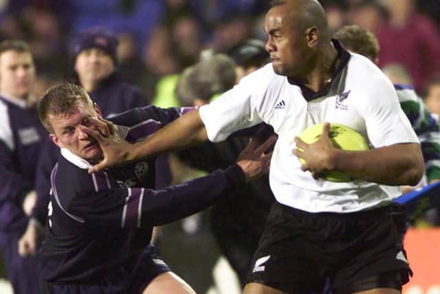 All Black Jonah Lomu plants his hand in the face of Scotland's Cameron Murray during the Second Test at Eden Park, Auckland in July 2000. Picture: Getty