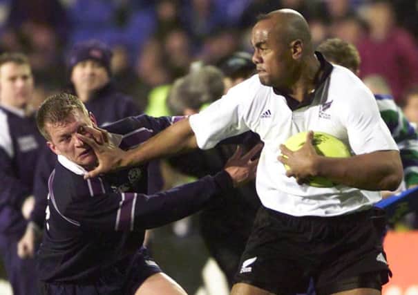 All Black Jonah Lomu plants his hand in the face of Scotland's Cameron Murray during the Second Test at Eden Park, Auckland in July 2000. Picture: Getty