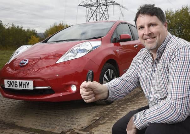 Neil Swanson with his Nissan Leaf. He won a years free loan, 
but couldnt wait and bought the car. Picture: Greg Macvean