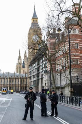 Armed police stand guard outside the Houses of Parliament after the terrorist attack. Picture: Getty Images