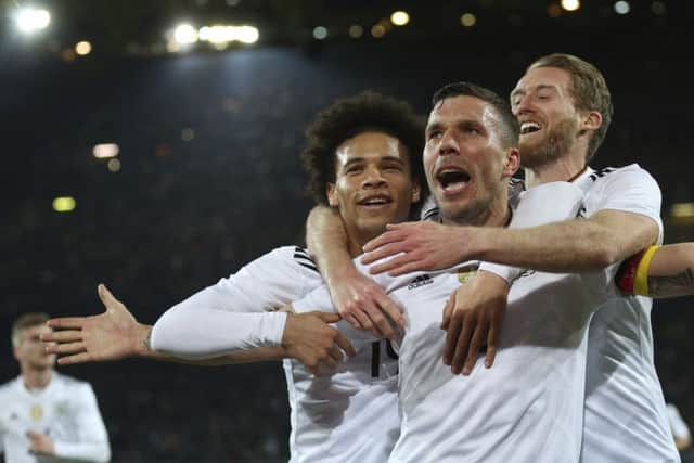 Germany's Lukas Podolski celebrates with his teammates Leroy Sane, left, and Andre Schuerrle, right, after scoring the only goal. Picture: Ina Fassbender