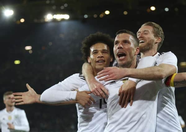 Germany's Lukas Podolski celebrates with his teammates Leroy Sane, left, and Andre Schuerrle, right, after scoring the only goal. Picture: Ina Fassbender