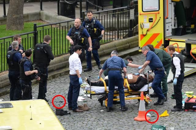 Emergency services at the scene while two knives lay on the floor outside the Palace of Westminster, London, after a policeman was stabbed and his apparent attacker shot by officers Picture: Stefan Rousseau/PA Wire