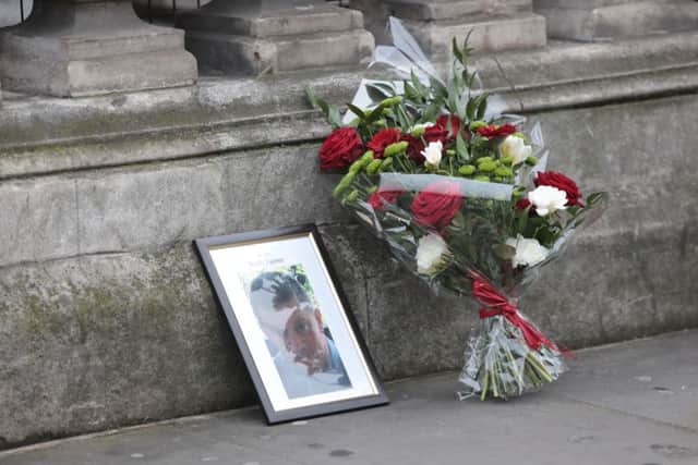 A floral tribute left by a member of the public sits next to a photo of Pc Keith Palmer in London. Picture: Getty Images
