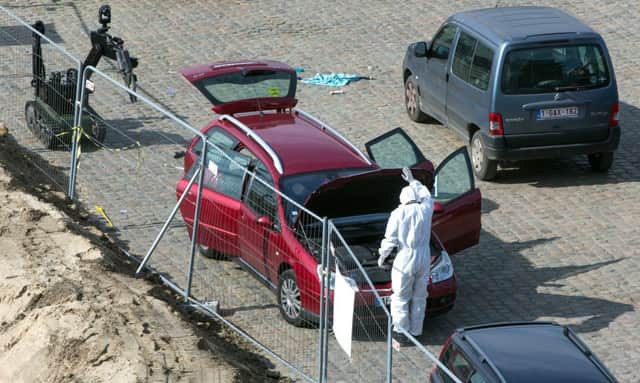 A police inspector searches around a car near the river in Antwerp. (Joris Herregods via AP)