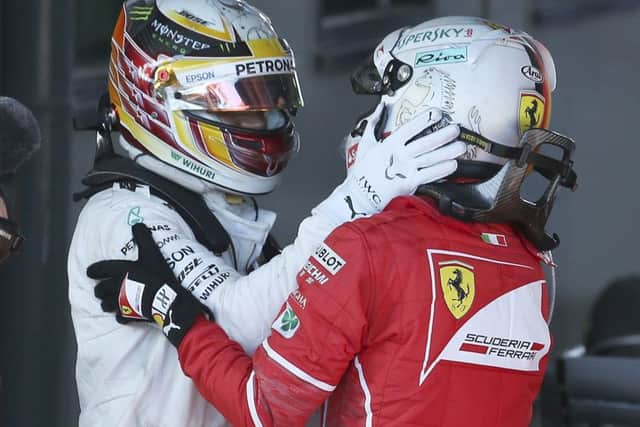 Sebastian Vettel, right, and Lewis Hamilton embrace after the Australian  Grand Prix. Picture: AP.