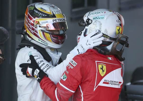 Sebastian Vettel, right, and Lewis Hamilton embrace after the Australian  Grand Prix. Picture: AP.