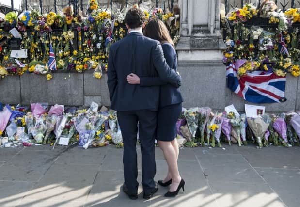 A couple look at floral tributes to the victims of the Westminster terrorist attack. Picture: Lauren Hurley/PA Wire