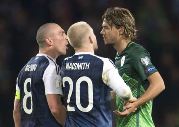 Scott Brown (left) exchanges words with Slovenia's Rene Krhin during Sunday's game. Picture: SNS