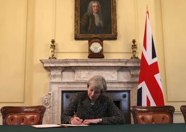 Theresa May signs the letter which will begin Britain's departure from the European Union. Picture: Christopher Furlong - WPA Pool/Getty Images