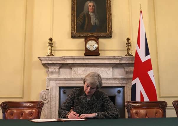 Theresa May signs the letter which will begin Britain's departure from the European Union.  Picture: Christopher Furlong - WPA Pool/Getty Images
