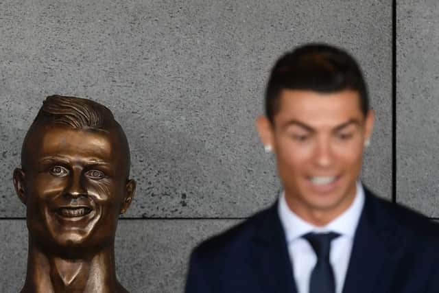 Cristiano Ronaldo stands beside a bust presented during a ceremony to rename Madeira's airport in Funchal in his honour. Picture: Francisco Leong/AFP/Getty Images
