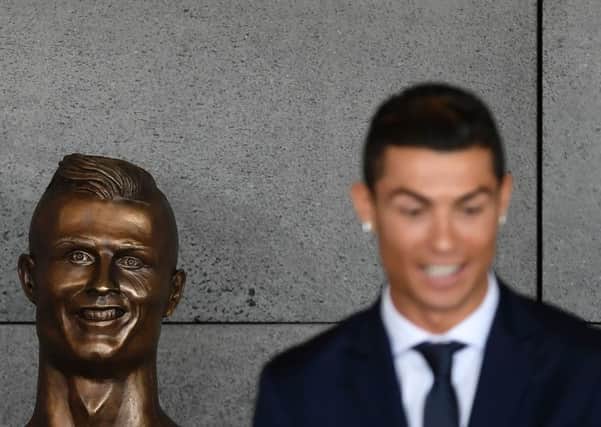 Cristiano Ronaldo stands beside a bust presented during a ceremony to rename Madeira's airport in Funchal in his honour. Picture: Francisco Leong/AFP/Getty Images
