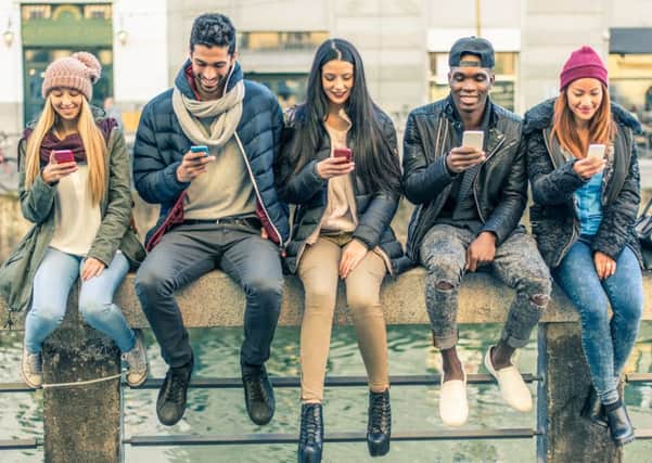 Too many of us are obsessed with scanning, swiping and selfie-ing on our mobiles and ignoring the people around us. Picture: Getty