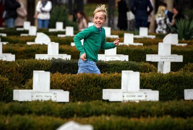 A young boy runs between cross headstones at the French soldiers' cemetery in Belgrade (Photo: ANDREJ ISAKOVIC/AFP/Getty Images)