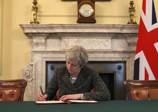 Theresa May signs the official letter to European Council President Donald Tusk invoking Article 50 in the cabinet office of 10 Downing Street. Picture: Christopher Furlong/Getty