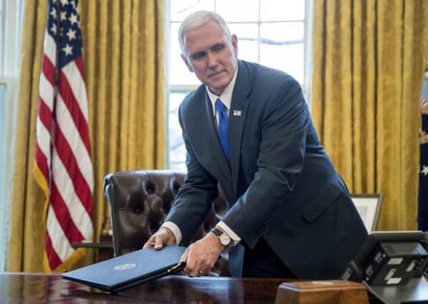 Pence retrieves a folder after Donald Trumps sudden departure from the Oval Office on Friday. Picture: Andrew Harnik/AP