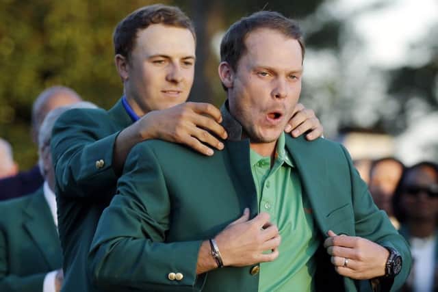 The magical moment when Masters winner Danny Willett is helped on with the green jacket by 2015 champion Jordan Spieth. Picture: Chris Carlson/AP