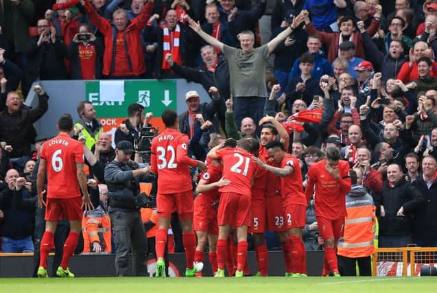 Divock Origi is mobbed by his team-mates after scoring Liverpool's third goal in the Merseyside derby. Picture: Peter Byrne/PA Wire