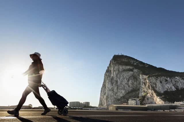 A woman walks on the Spanish side of the border between Spain and the British overseas territory of Gibraltar with the iconic Rock of Gibraltar in the background. Picture: AP Photo/Daniel Ochoa de Olza