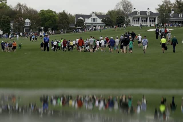 Fans leave the course after a weather warning was issued during the first official practice day for the 81st Masters. Picture: AP