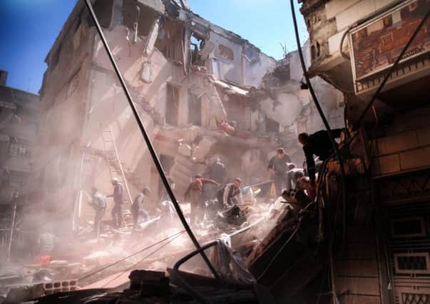 Members of the Syrian civil defence volunteers look for survivors from the rubble following reported airstrikes on the town of Saqba. Picture: AFP/Getty Images