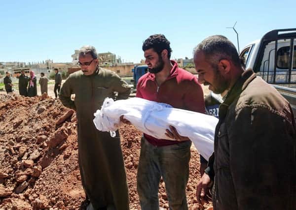Syrians bury the bodies of victims of a a suspected toxic gas attack in Khan Sheikhun, a nearby rebel-held town in Syrias northwestern Idlib province / AFP PHOTO / FADI AL-HALABIFADI AL-HALABI/AFP/Getty Images