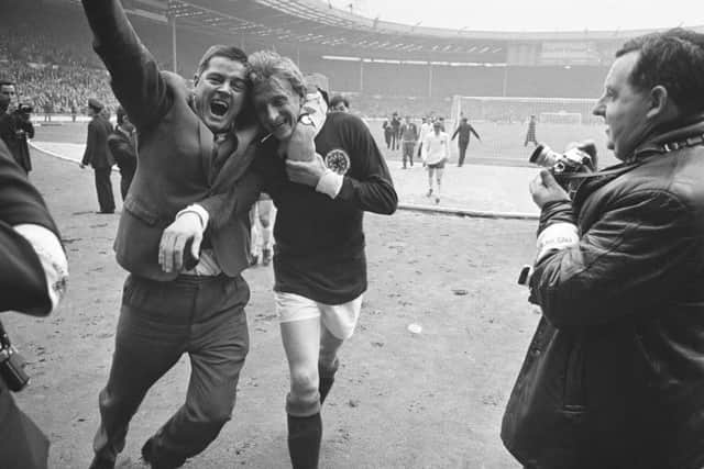 Peter Dallas, who is portrayed in the play, wraps his arm around Denis Law in a victory salute. Picture: Getty Images