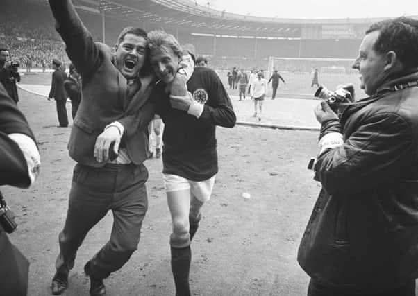 Peter Dallas, who is portrayed in the play, wraps his arm around Denis Law in a victory salute. Picture: Getty Images