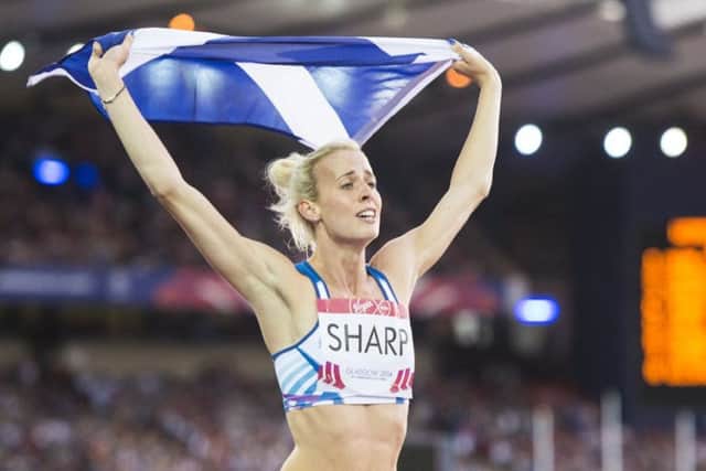 Lynsey Sharp proudly carries the Saltire after winning silver in the 800m at Hampden Park during the Glasgow 2014 games.