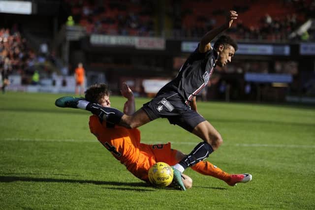 Dundee Uniteds Jamie Robson slides in on Falkirk striker Nathan Austin.  Picture Michael Gillen