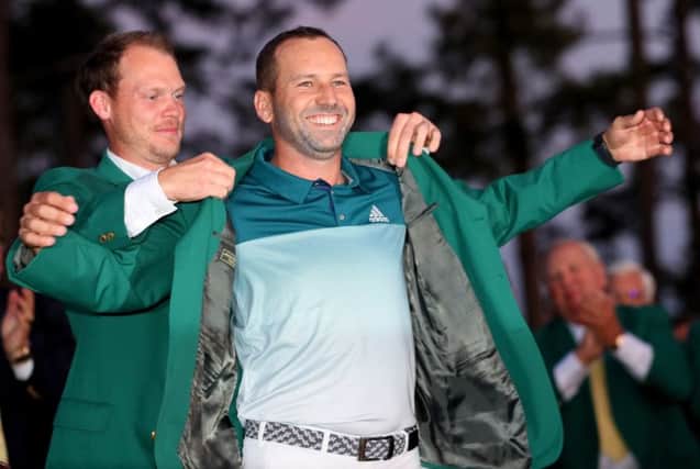 The smile on Sergio Garcia's face says it all as last year's winner Danny Willett slips the Green Jacket over his shoulders. Picture: Getty Images