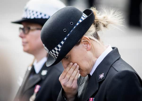 A female police officer closes her eyes as the funeral cortege of murdered police officer Keith Palmer leaves Southwark Cathedral, London. 10 April 2017. (photo: SWNS)