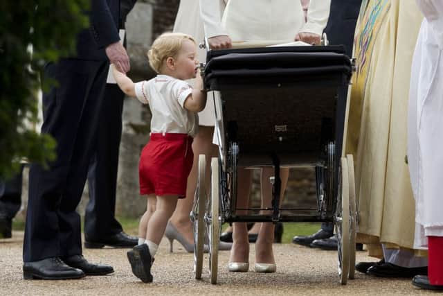 Prince George gets up on tiptoes to peek into the pram of Princess Charlotte  after Charlotte's Christening  (Photo: AP Photo/Matt Dunham)