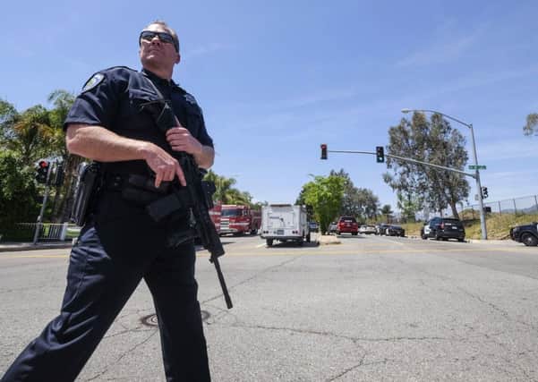A police office stands guard outside North Park School after a fatal shooting (AP Photo/Ringo H.W. Chiu)