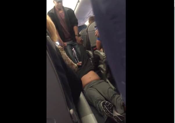 A screengrab from a video shows the man being dragged off the aircraft. Picture: Contributed