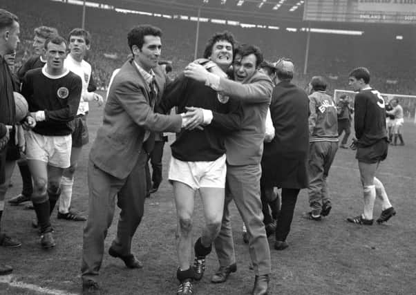 Scotland's Jim Baxter is hugged by fans who invaded the pitch at Wembley following the 3-2 victory over England. Picture: PA