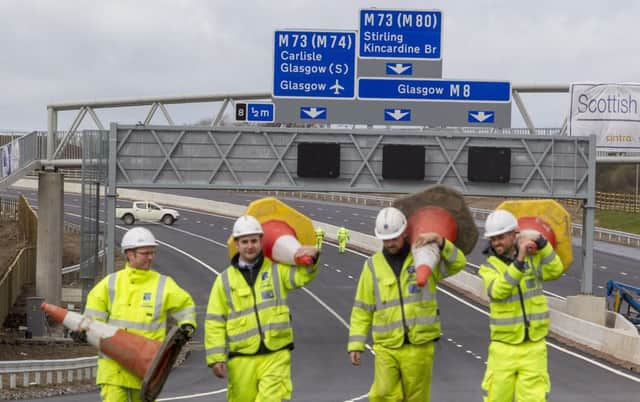 Engineers clear cones from the M8 'missing link' before its opening this month. Picture: SWNS