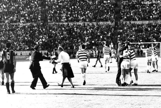 A Portuguese policeman tries to remove a Celtic fan, wearing a kilt, after he had run onto the pitch after Celtic had scored the winning goal against the Italians. Picture: contributed